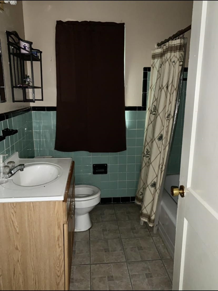 3741 Rhodes Avenue Memphis, TN 38111 - Photo 3 of 5 Full bathroom featuring shower / bathtub combination with curtain, tile floors, tile walls, vanity, and toilet