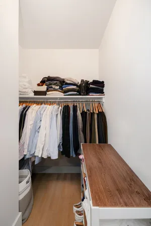 a view of walk in closet with clothes and shoes