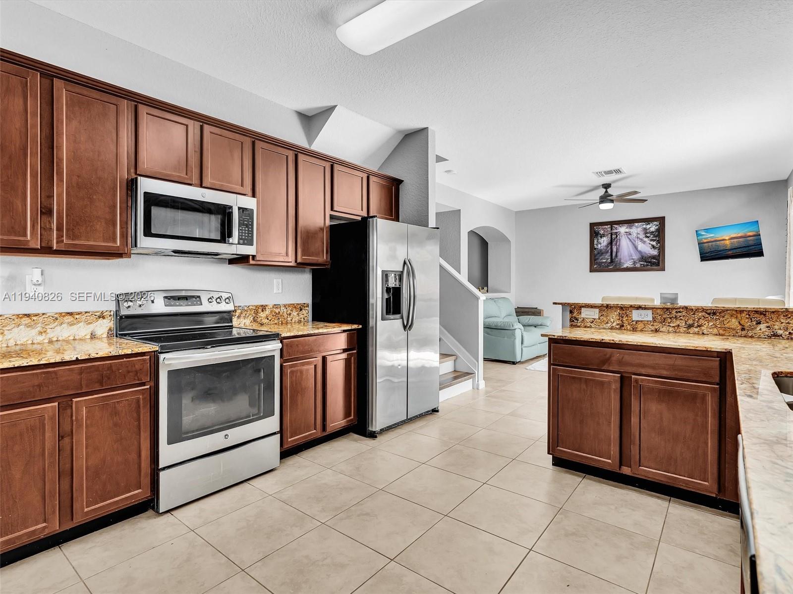 625 Southeast 30th Terrace Homestead, FL 33033 - Photo 18 of 71 a kitchen with stainless steel appliances granite countertop a stove top oven a refrigerator and a microwave