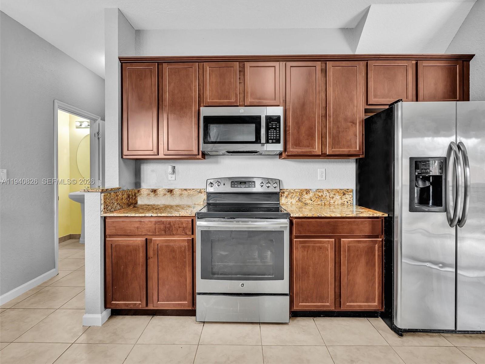625 Southeast 30th Terrace Homestead, FL 33033 - Photo 19 of 71 a kitchen with stainless steel appliances granite countertop a refrigerator stove a sink and a microwave