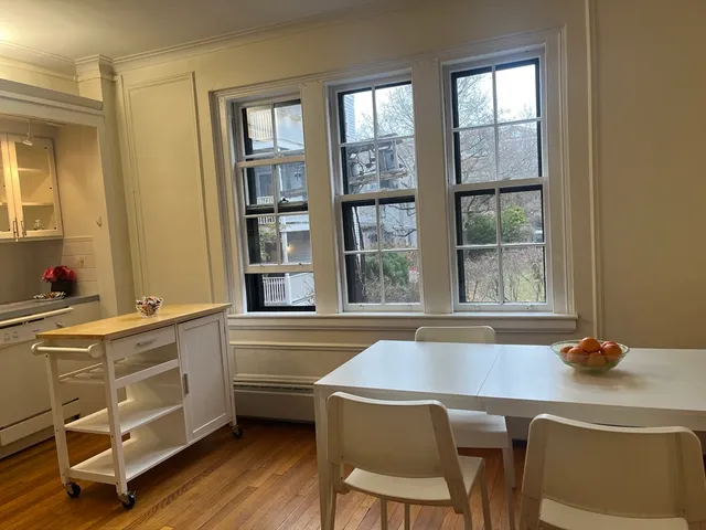a dining room with a desk chairs and chandelier