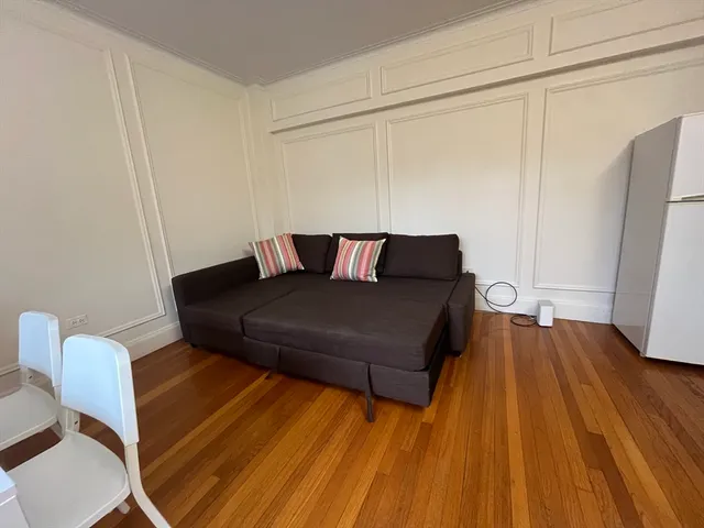 a living room with a couch wooden floor and a table