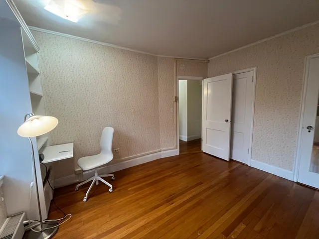a view of a room with wooden floor and a chair