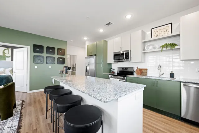 a kitchen with sink a stove and chairs