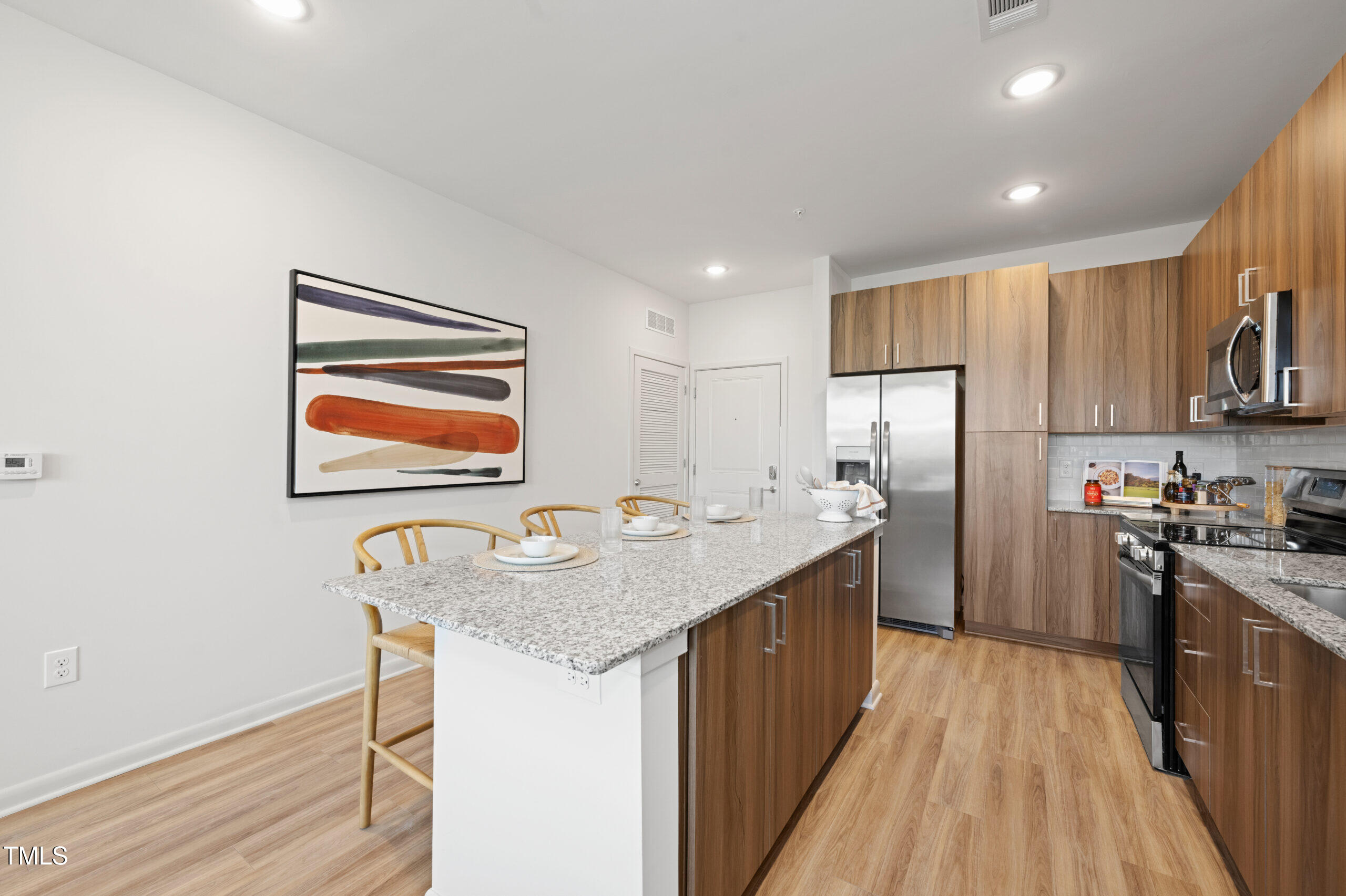 211 Hammond Center Drive, Unit A1 Raleigh, NC 27603 - Photo 8 of 30 a kitchen with stainless steel appliances granite countertop a sink stove and refrigerator