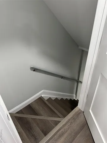 an empty room with wooden floor fireplace and cabinet