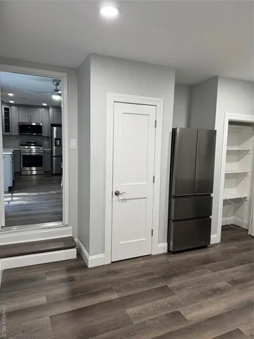 an empty room with wooden floor and cabinet