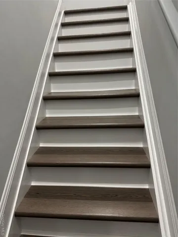 an empty room with wooden floor and entrance