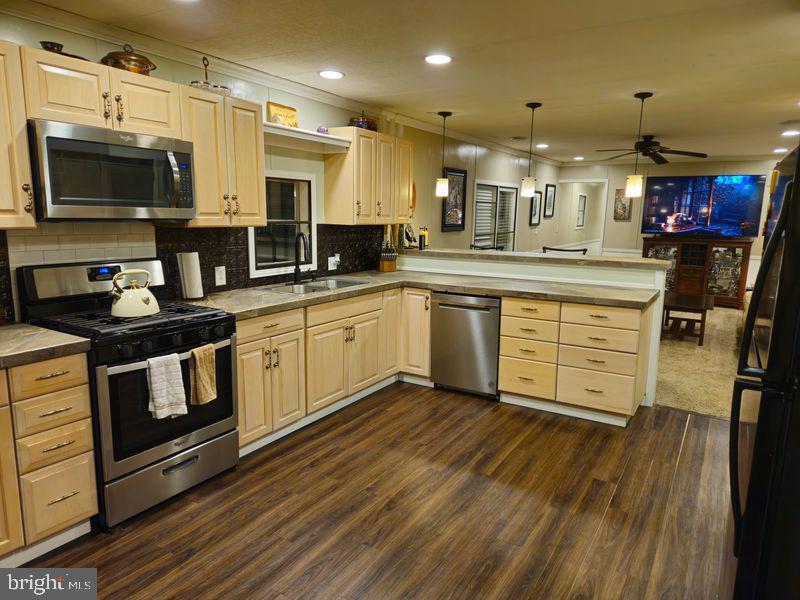 1008 Marticville Road Pequea, PA 17565 - Photo 6 of 27 a kitchen with stainless steel appliances granite countertop a sink a stove top oven and wooden floors