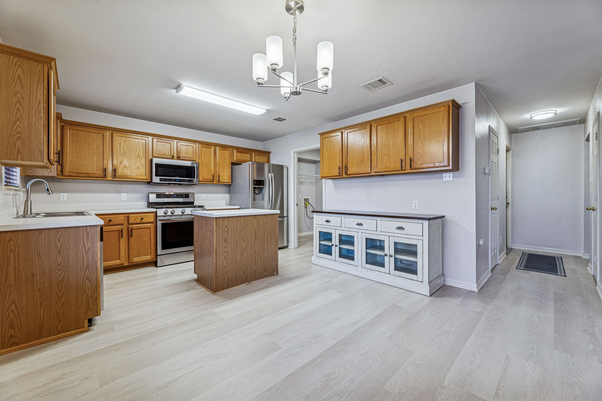 1608 Melibee Trail Austin, TX 78748 - Photo 8 of 29 Kitchen featuring wood finish cabinets, stainless steel appliances, hanging lights, and a kitchen island
