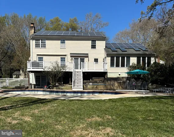 a front view of a building with swimming pool and porch