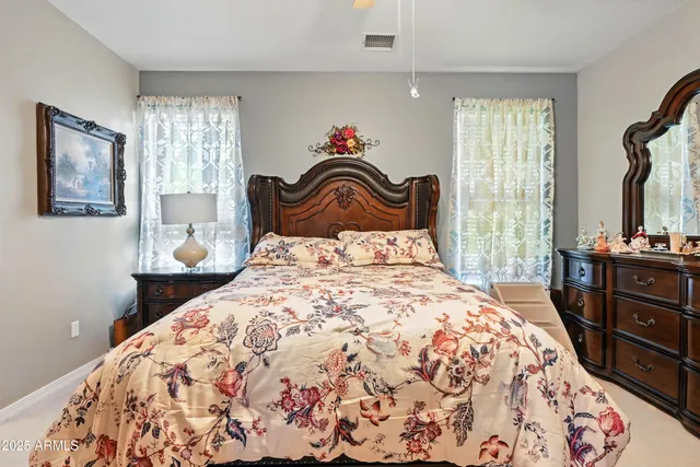 a bedroom with a bed and a dresser with mirror