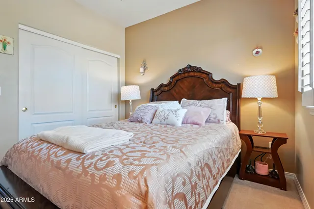 a bedroom with a bed and a lamp on dresser