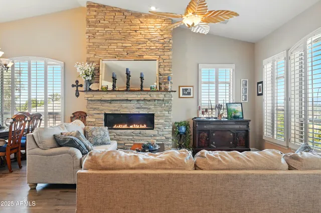 a living room with furniture a fireplace and a large window