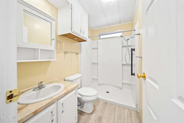 a bathroom with a sink a toilet and shower