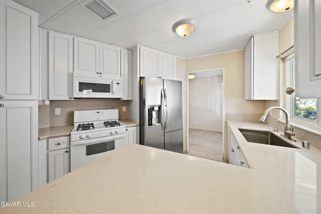 a kitchen with stainless steel appliances a refrigerator stove microwave and sink