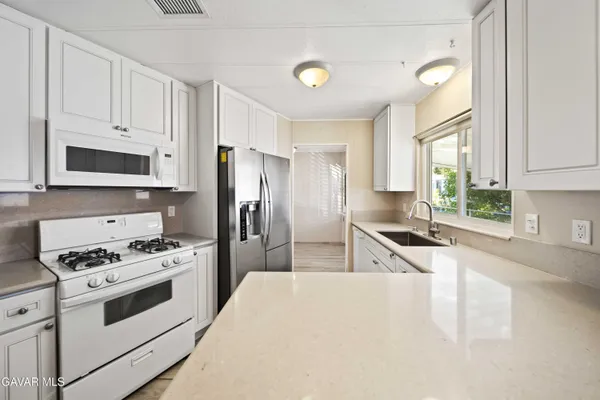 a kitchen with stainless steel appliances a refrigerator stove microwave and sink