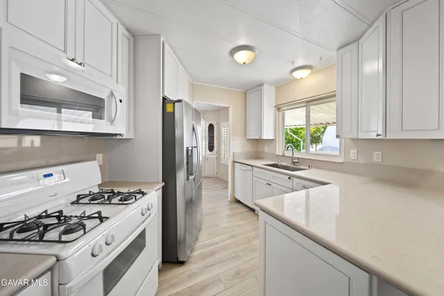 a kitchen with a sink cabinets and stainless steel appliances