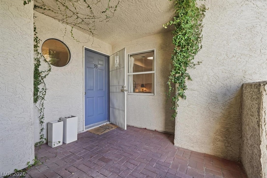 6250 West Flamingo Road, Unit 93 Las Vegas, NV 89103 - Photo 7 of 38 This charming entry features a distinct blue door, a circular window, and inviting brick pavers.