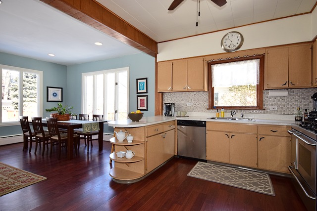 180 Fairbank Road Riverside, IL 60546 - Photo 10 of 25 a kitchen with stainless steel appliances granite countertop a stove a sink dishwasher a dining table and chairs with wooden floor