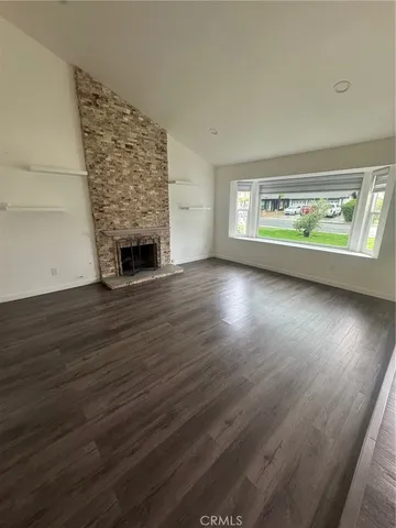 a kitchen with stainless steel appliances a stove a sink and white cabinets with wooden floor