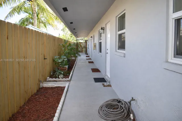 a view of a house with backyard and wooden fence