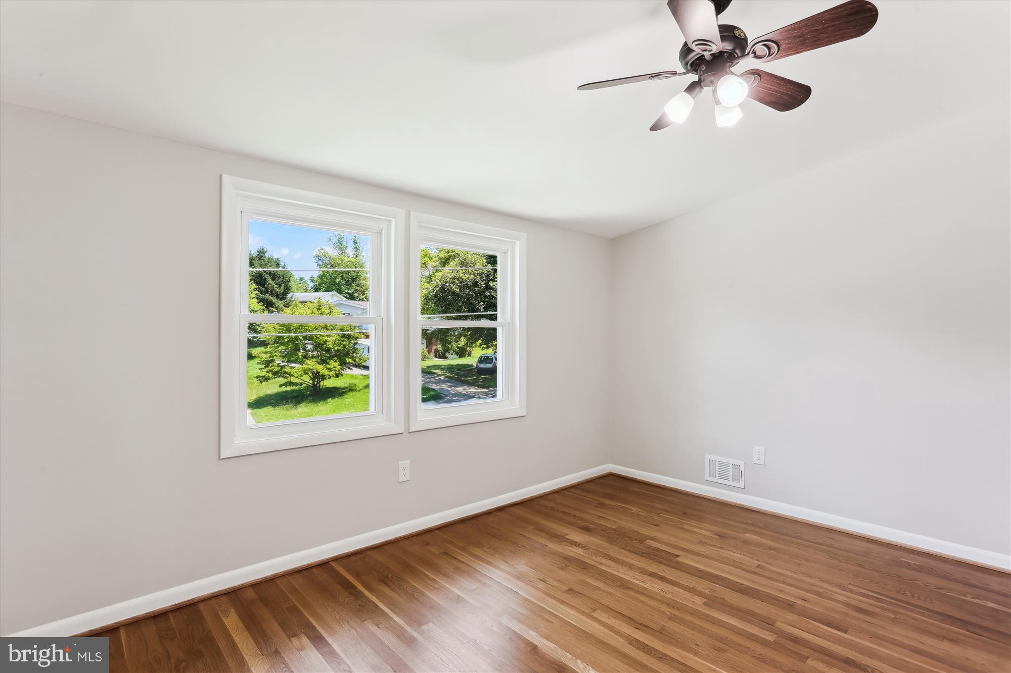 11524 Charlton Drive Silver Spring, MD 20902 - Photo 38 of 64 an empty room with wooden floor fan and windows