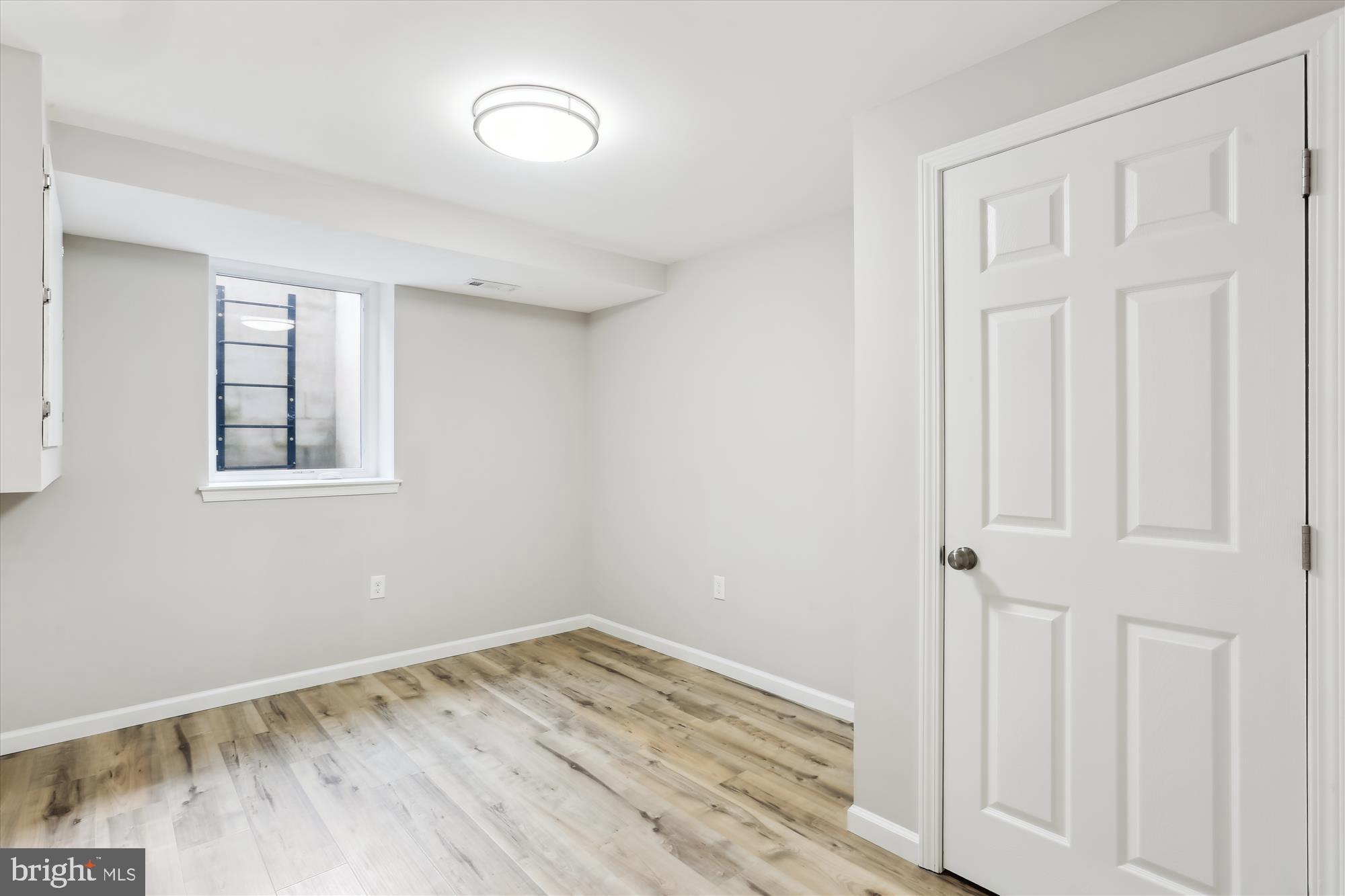 11524 Charlton Drive Silver Spring, MD 20902 - Photo 50 of 64 an empty room with wooden floor and windows