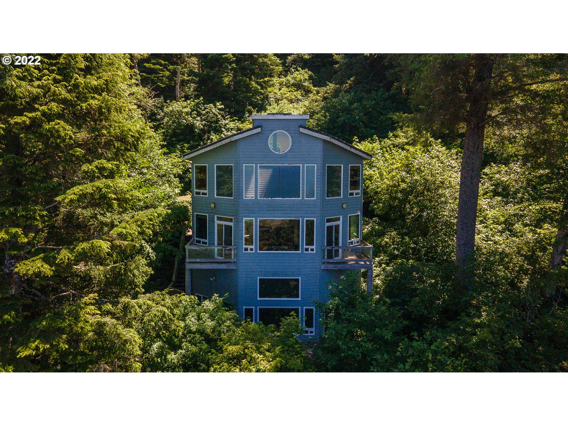 230 Crestview Drive Yachats, OR 97498 - Photo 4 of 31 a black and white photo of a house in a forest