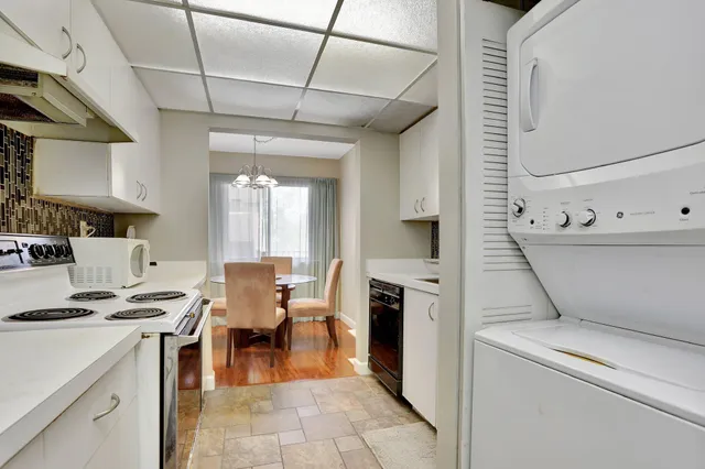 a open kitchen that has a lot of white cabinets and stainless steel appliances