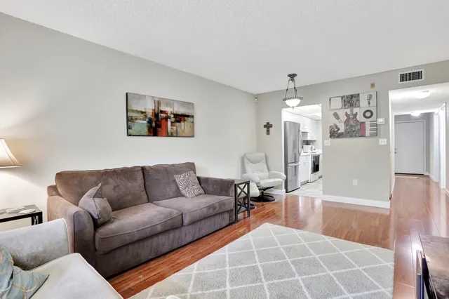 a living room with furniture and a chandelier