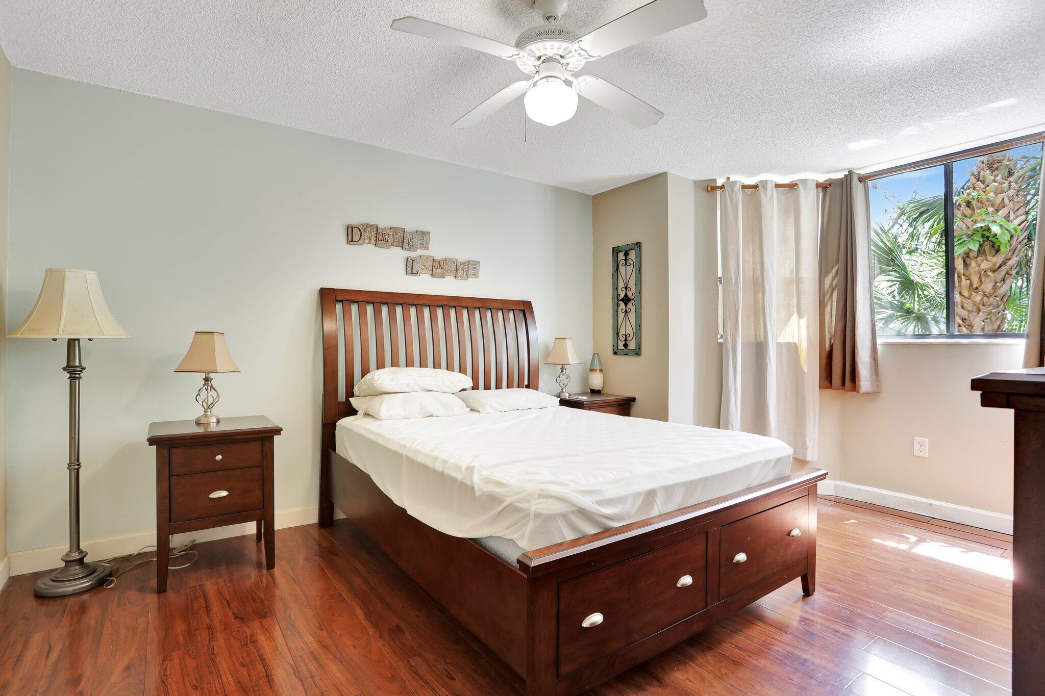 7451 Northwest 16th Street, Unit 303 Plantation, FL 33313 - Photo 20 of 41 a bedroom with a bed and a chandelier