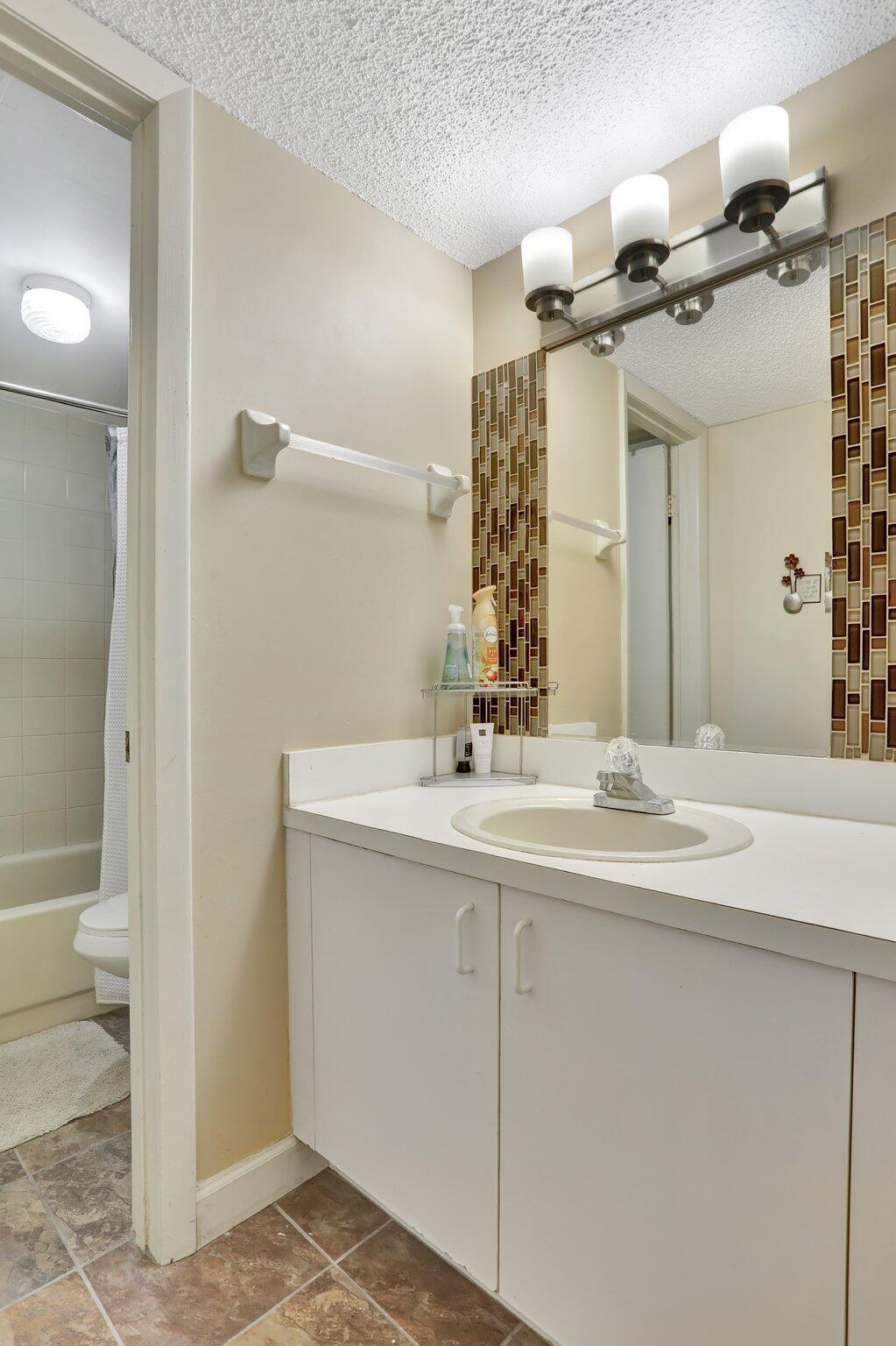 7451 Northwest 16th Street, Unit 303 Plantation, FL 33313 - Photo 24 of 41 a bathroom with a sink and a mirror