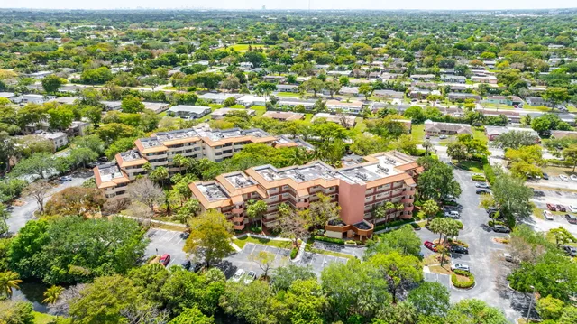 an aerial view of residential houses with outdoor space and trees