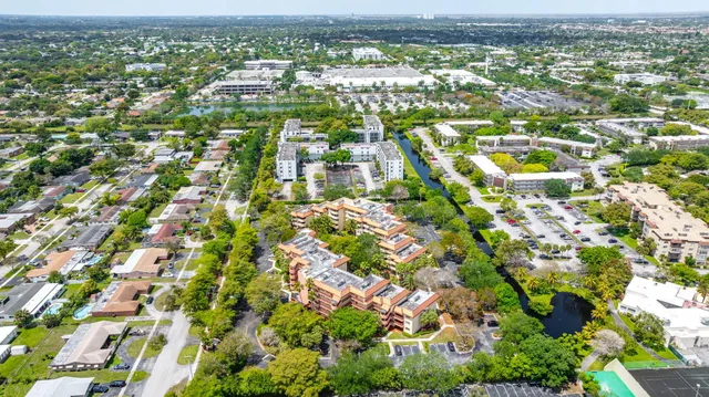 an aerial view of residential houses with outdoor space and trees