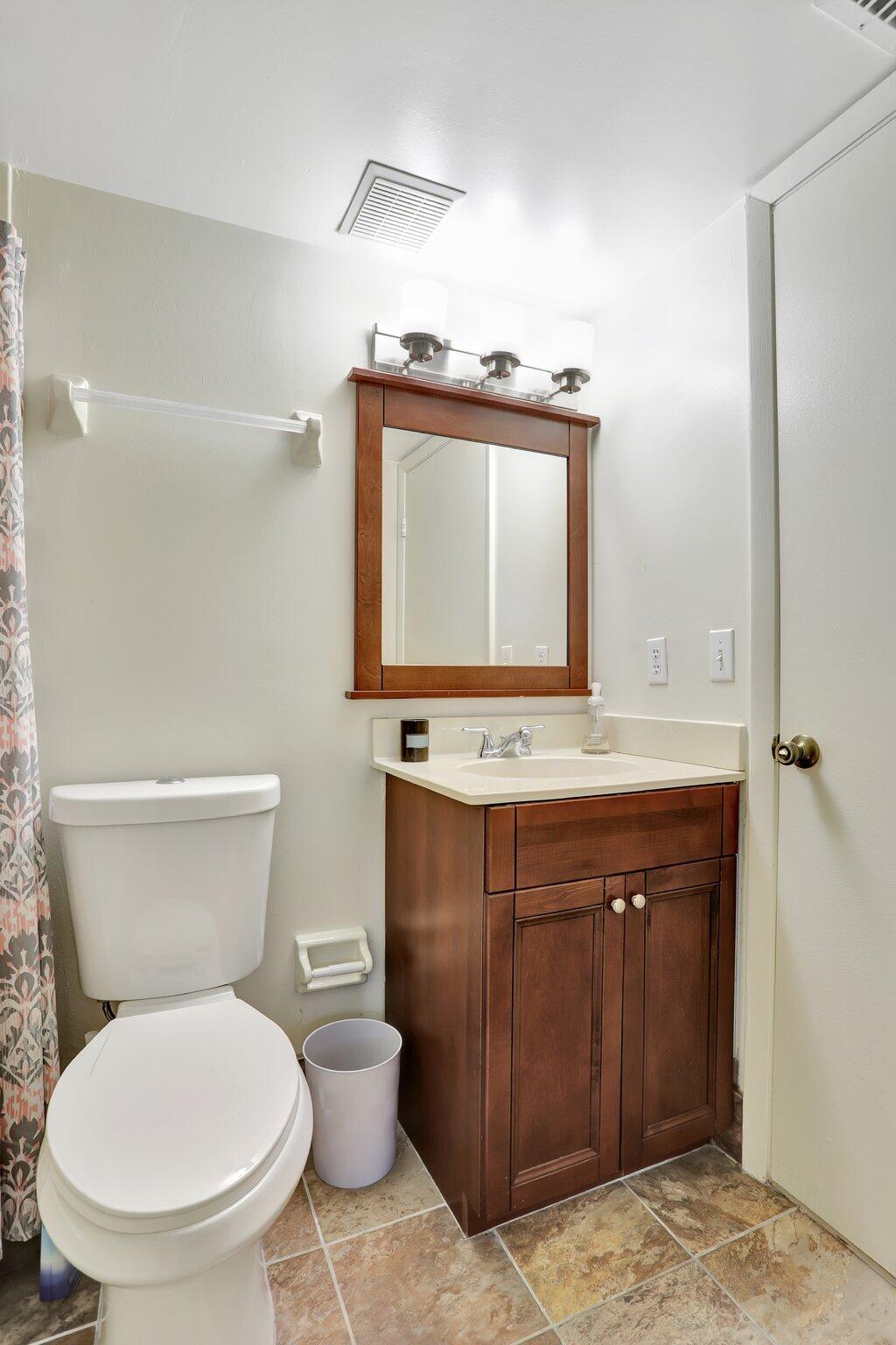 7451 Northwest 16th Street, Unit 303 Plantation, FL 33313 - Photo 9 of 41 a bathroom with a toilet sink and mirror