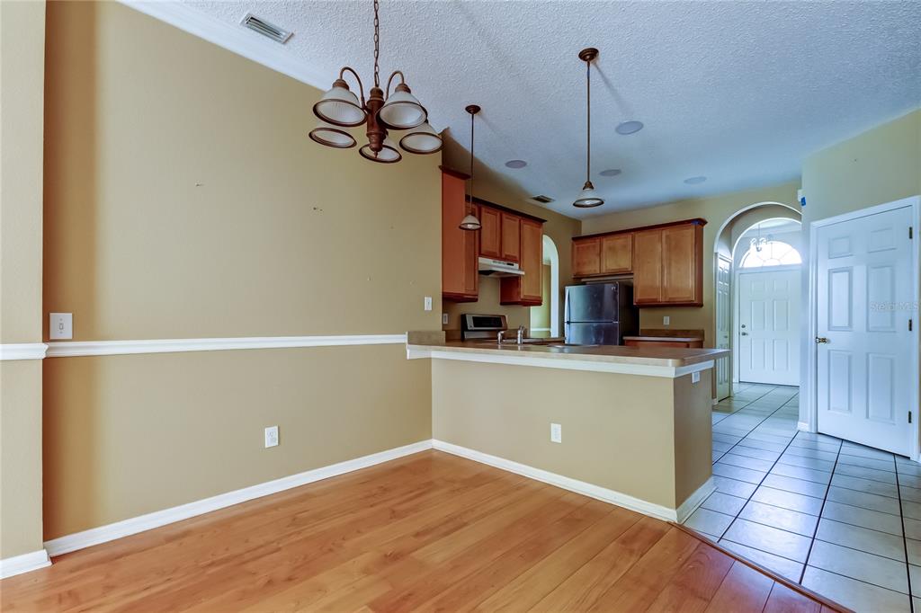 10708 Northridge Court Trinity, FL 34655 - Photo 12 of 58 a kitchen with kitchen island a counter top space appliances and a ceiling fan
