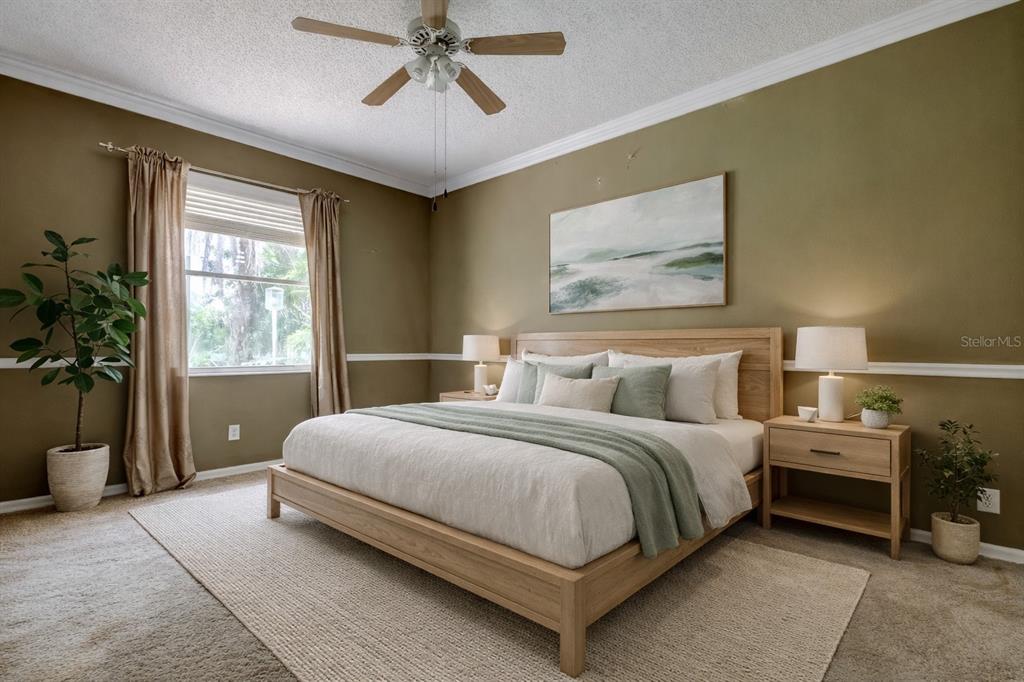 10708 Northridge Court Trinity, FL 34655 - Photo 14 of 58 a bedroom with a large bed and a chandelier fan