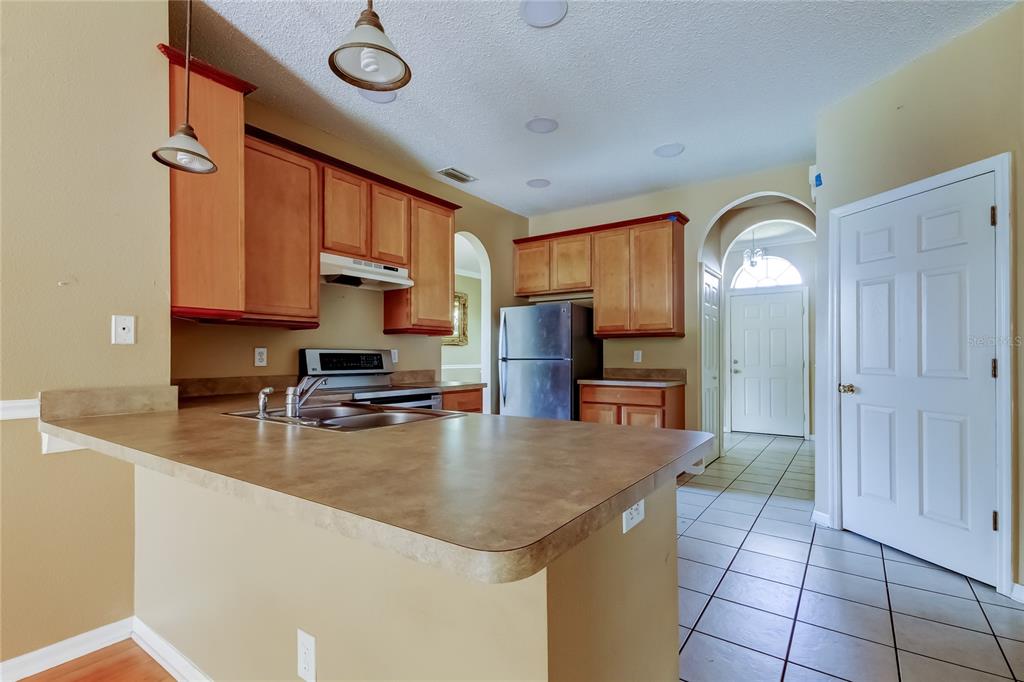 10708 Northridge Court Trinity, FL 34655 - Photo 43 of 58 a kitchen with a refrigerator a sink and cabinets