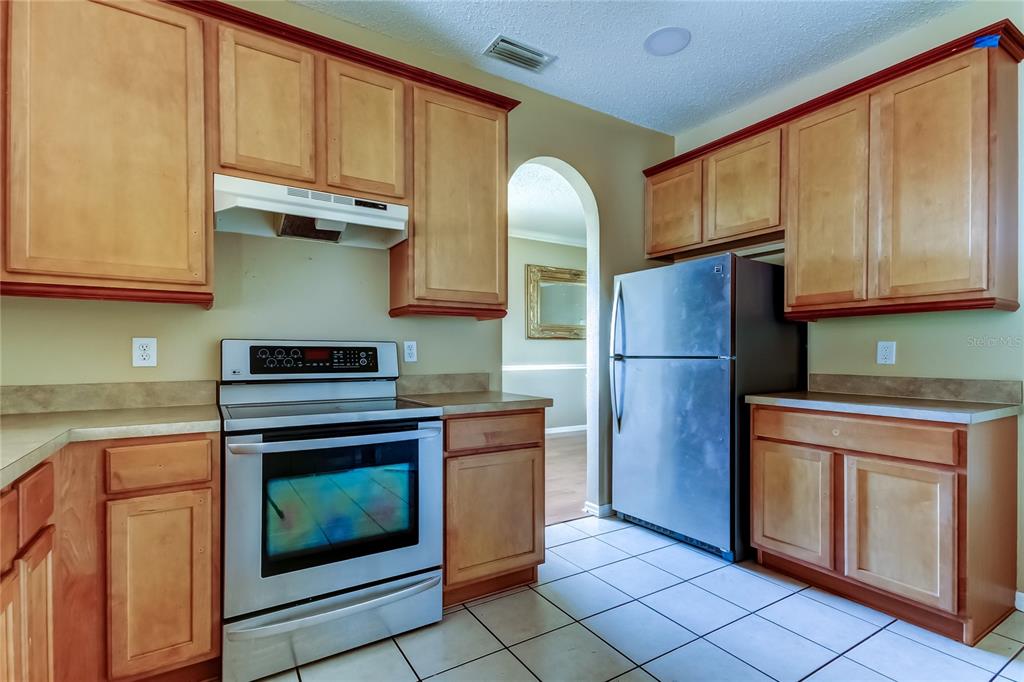 10708 Northridge Court Trinity, FL 34655 - Photo 7 of 58 a kitchen with granite countertop a refrigerator stove and cabinets