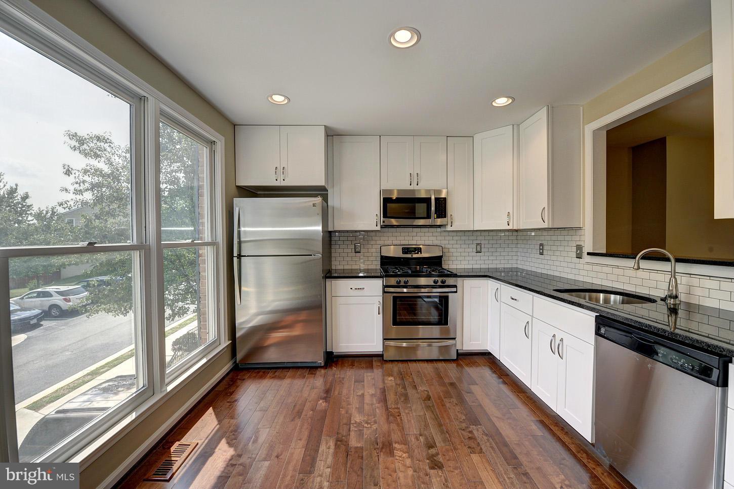 7706 Hickory Glen Way Springfield, VA 22153 - Photo 3 of 21 a kitchen with stainless steel appliances a refrigerator sink and microwave