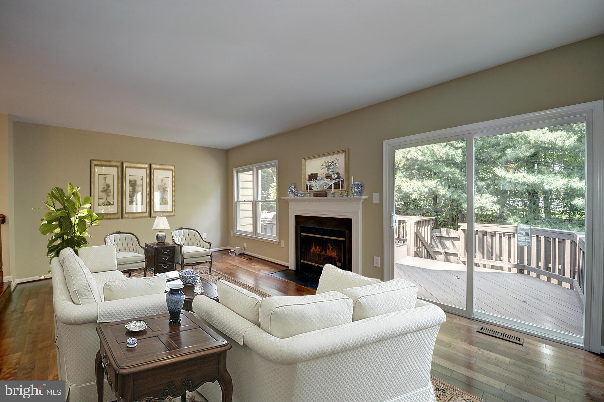 7706 Hickory Glen Way Springfield, VA 22153 - Photo 7 of 21 a living room with furniture a fireplace and a floor to ceiling window