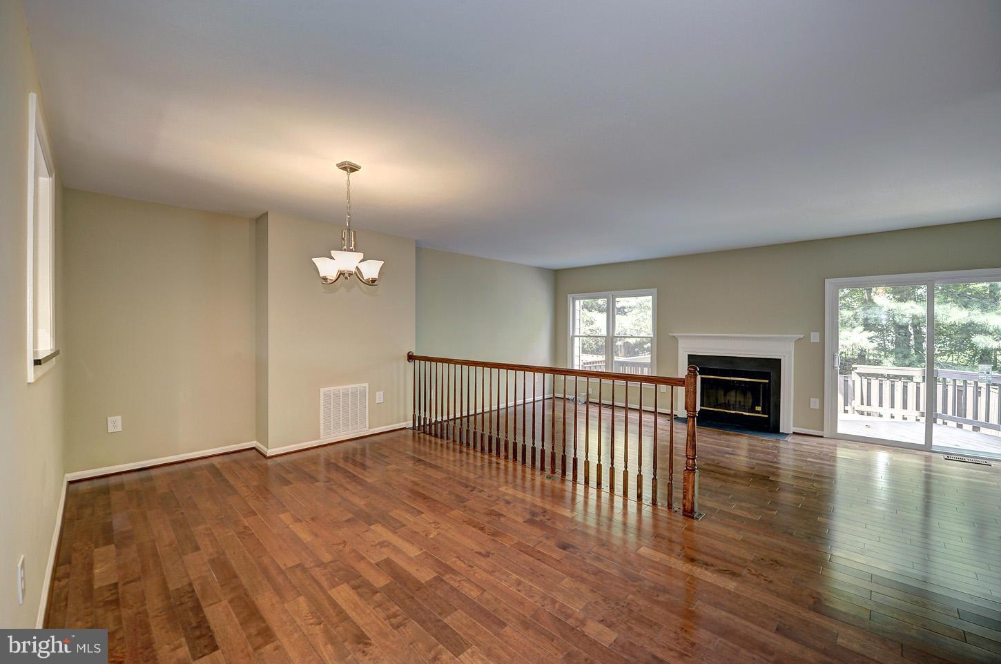 7706 Hickory Glen Way Springfield, VA 22153 - Photo 9 of 21 an empty room with wooden floor fireplace and windows