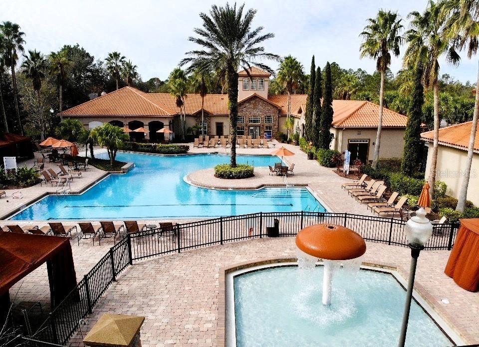 a view of a swimming pool with a table and chairs under an umbrella