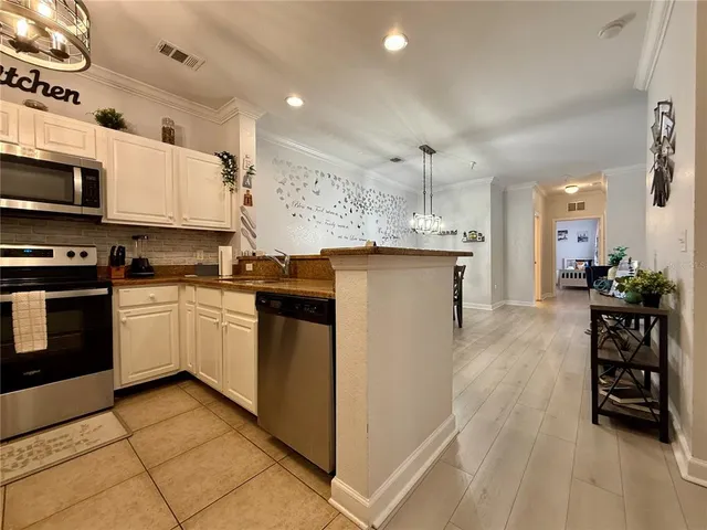 a kitchen with stainless steel appliances granite countertop a stove top oven a sink a counter space and cabinets