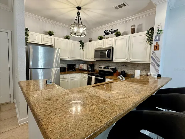 a kitchen with stainless steel appliances granite countertop a sink a stove and a refrigerator