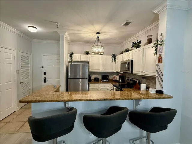 a kitchen with stainless steel appliances granite countertop a sink a stove and a refrigerator