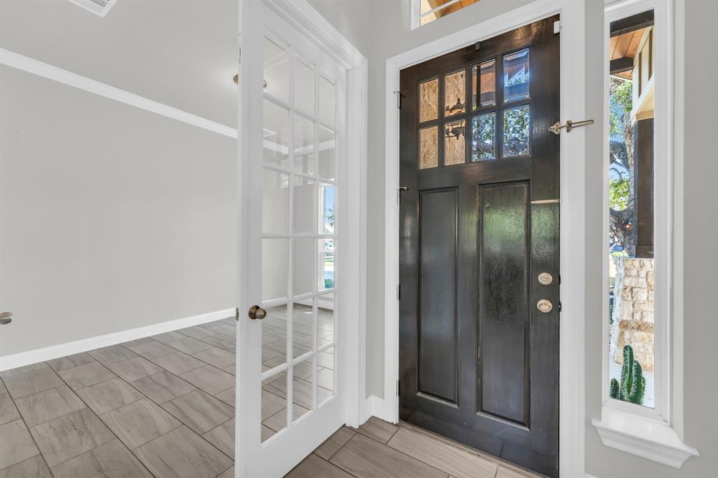 110 Magona Trail Georgetown, TX 78628 - Photo 7 of 38 A dark paneled front door opens into a bright, tiled foyer, adjacent to a room accessible via glass French doors.