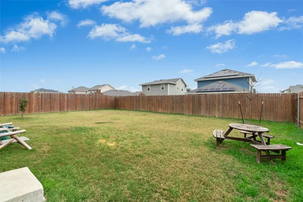 a view of a backyard with table and chairs