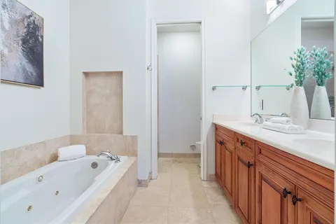 a bathroom with a tub a sink and a large mirror